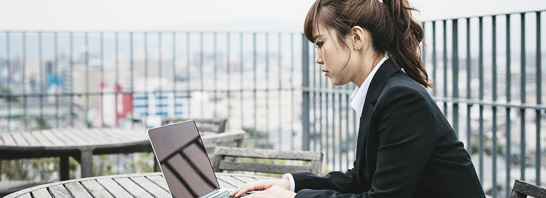 Nainen työskentelee kannettavalla tietokoneella ulkona Japanin Kiotossa